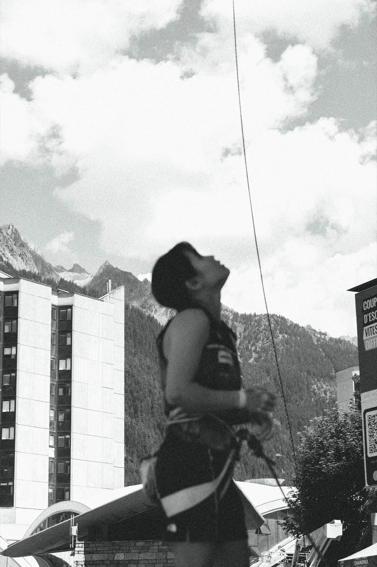 Athlete looking up at the route with Chamonix mountains in the background — b&w