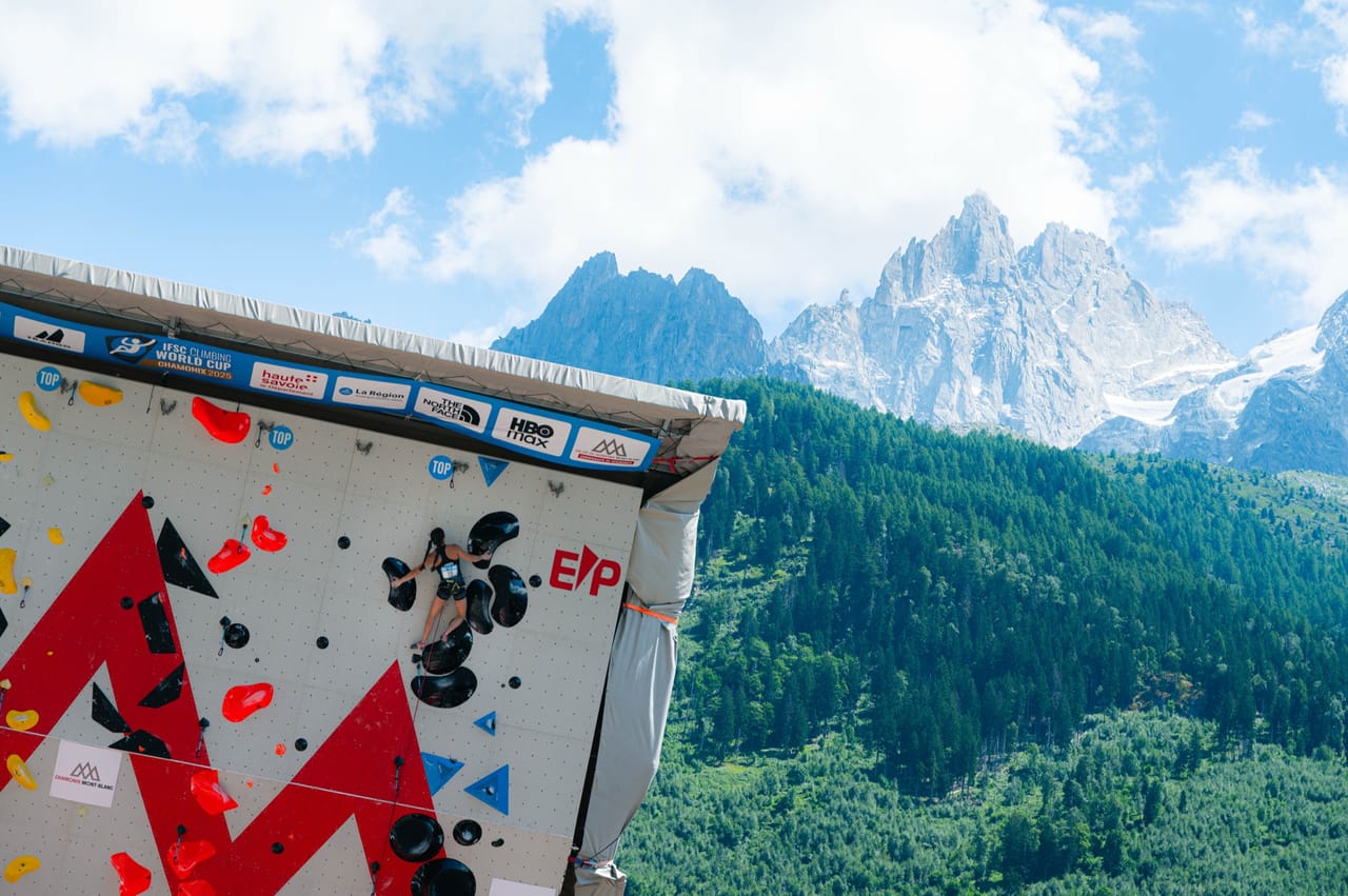 Climber on the IFSC competition wall with Mont Blanc massif in the background