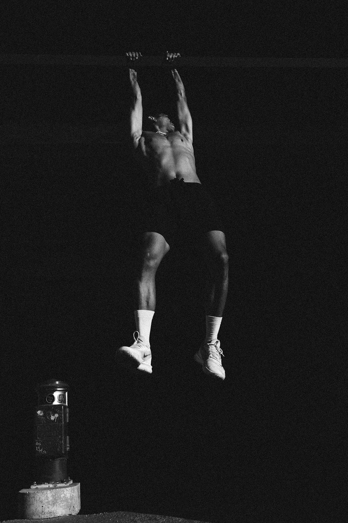 Parkour athlete hanging from a pole